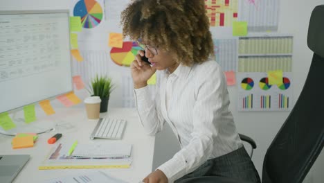 mulher pensativa no escritório falando no telefone