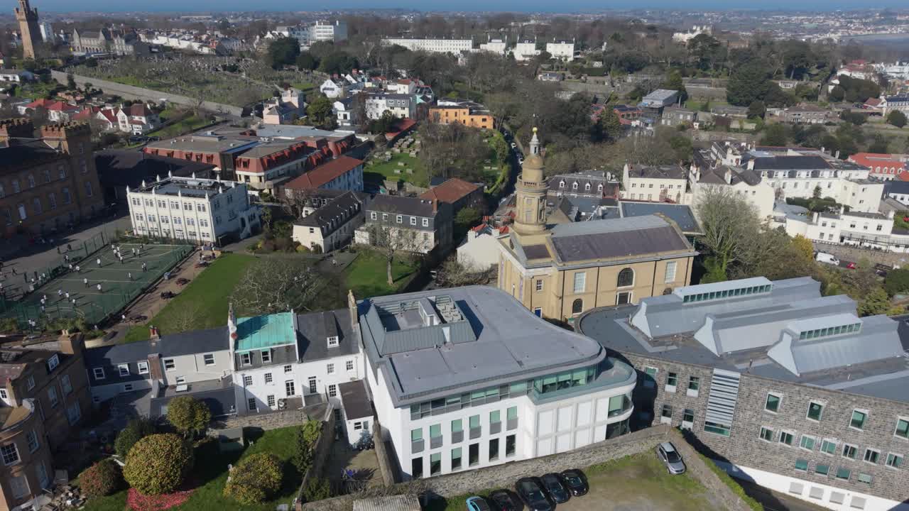 St Peter Port Guernsey, som viser St James Assembly Hall og Royal Court med utsikt over byen mot havet i ettermiddagssolen.