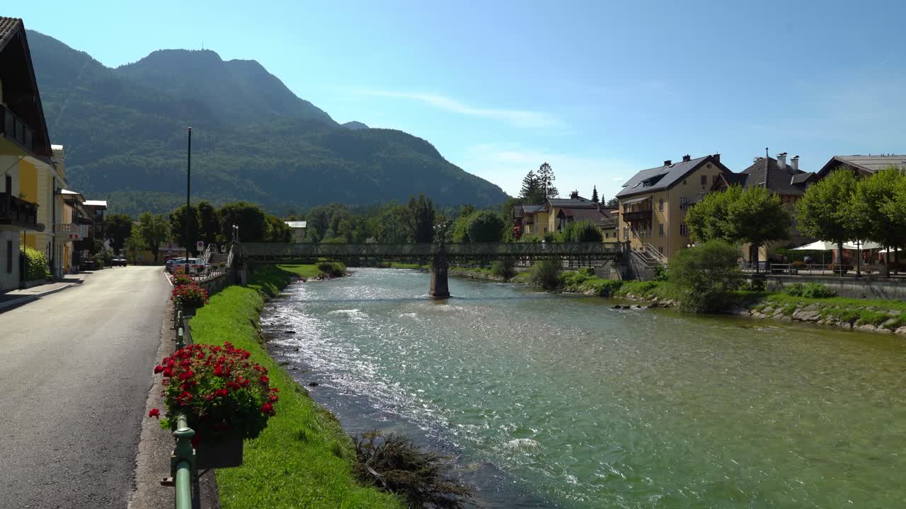 el río traun fluye a través de la ciudad balnearia de bad ischl en un día soleado con el puente en el fondo