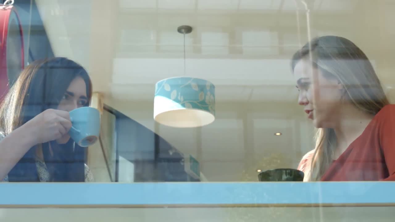 예쁜 카페에서 커피를 마시며 대화를 나누는 친구들