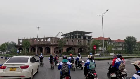 motorbikes and cars navigating a busy intersection