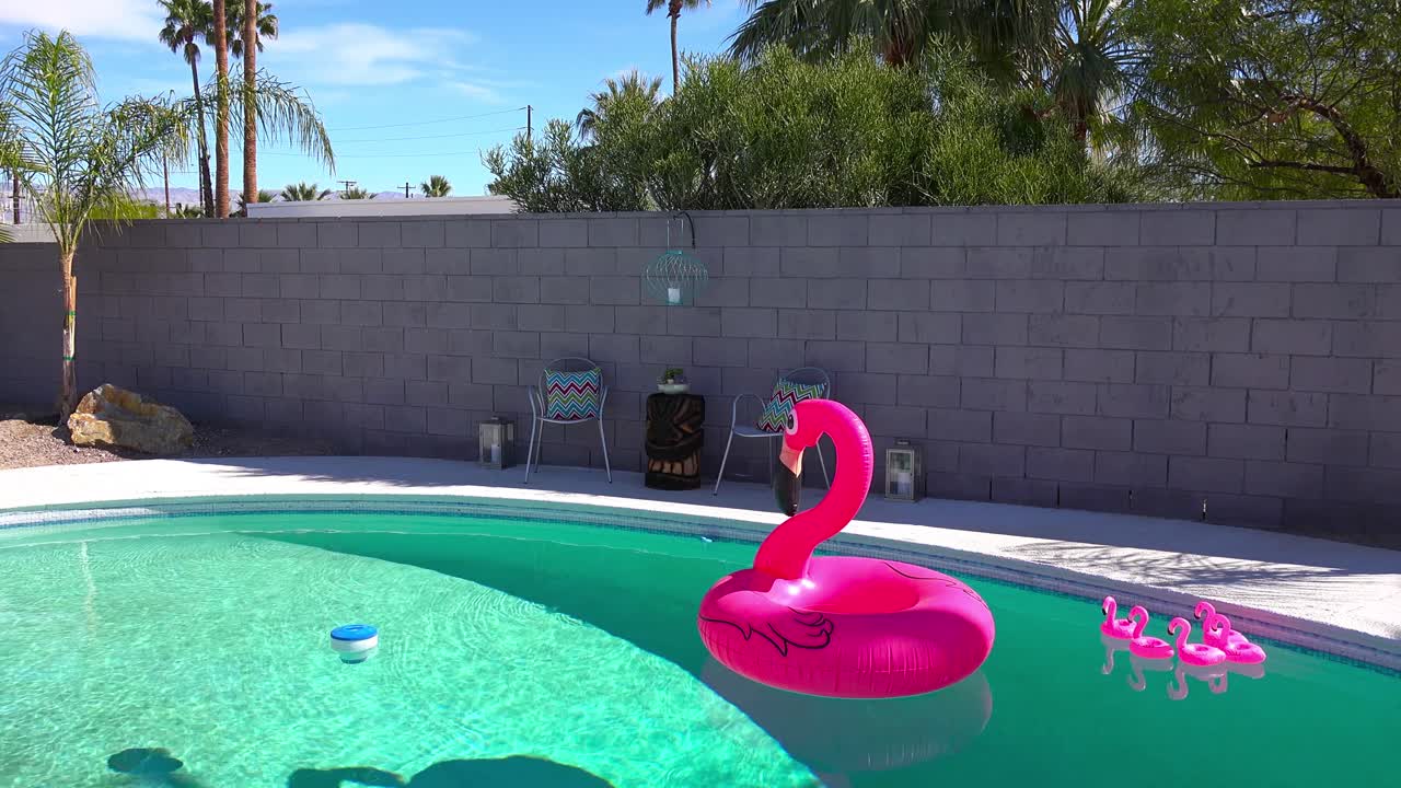 Ein künstlicher aufblasbarer Flamingo schwimmt in einem Swimmingpool an einem Haus in Palm Springs.