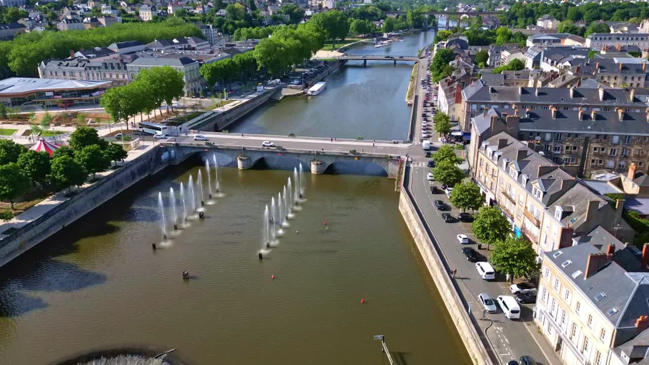 Low-angle drone hyperlapse showing Laval’s Mayenne river, bridge, 11 November Square, and city traffic on a sunny day.