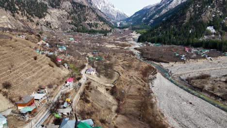 aerial drone shot capturing the essence of sangla village with its vibrant apple orchards and mountain scenery.