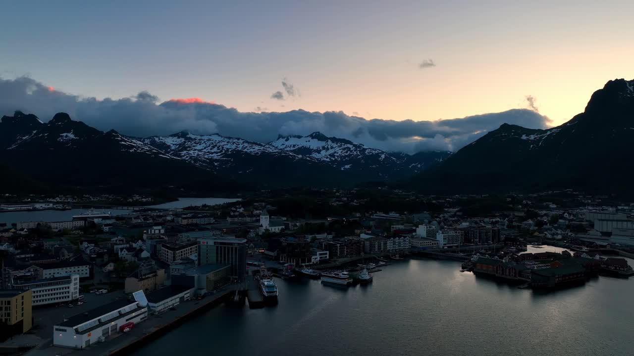 Quiet Svolvaer city center at midnight facing Storoya and Kongstind with golden sky and clouds