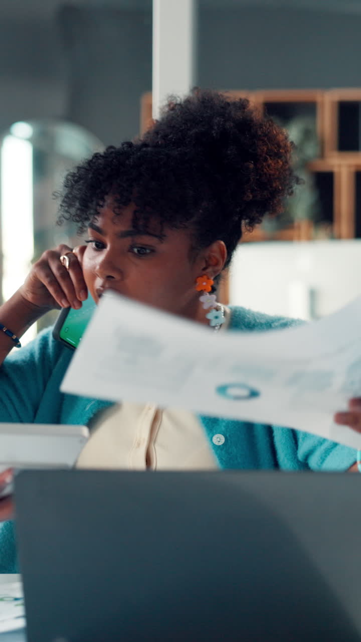Young Black Woman Working on Laptop and Talking on Phone in Office