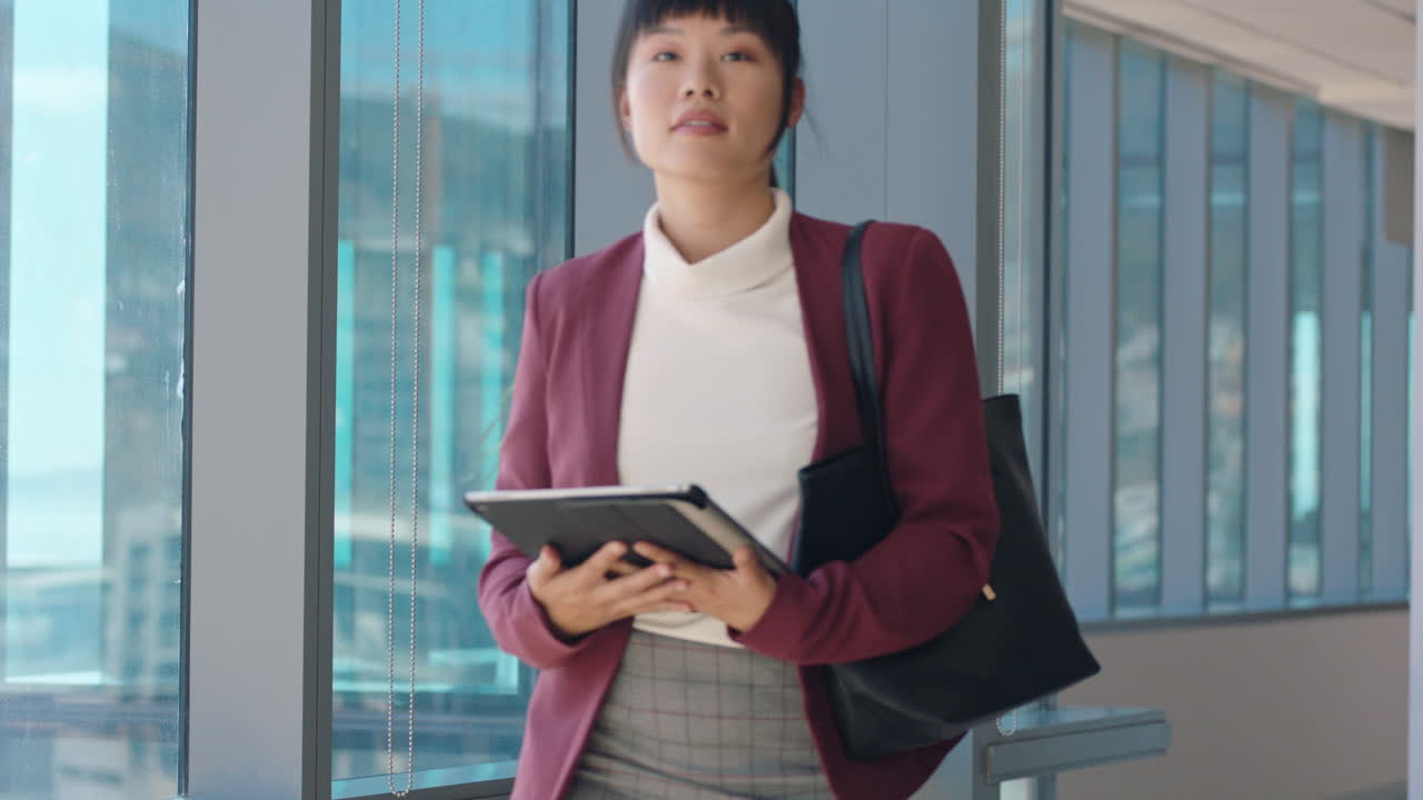 タブレットコンピュータを使った魅力的なビジネスウーマン ⁇ オフィスを歩いて ⁇ 企業経営のキャリアを楽しんで ⁇ モバイルデバイスでメールをチェックしています ⁇
