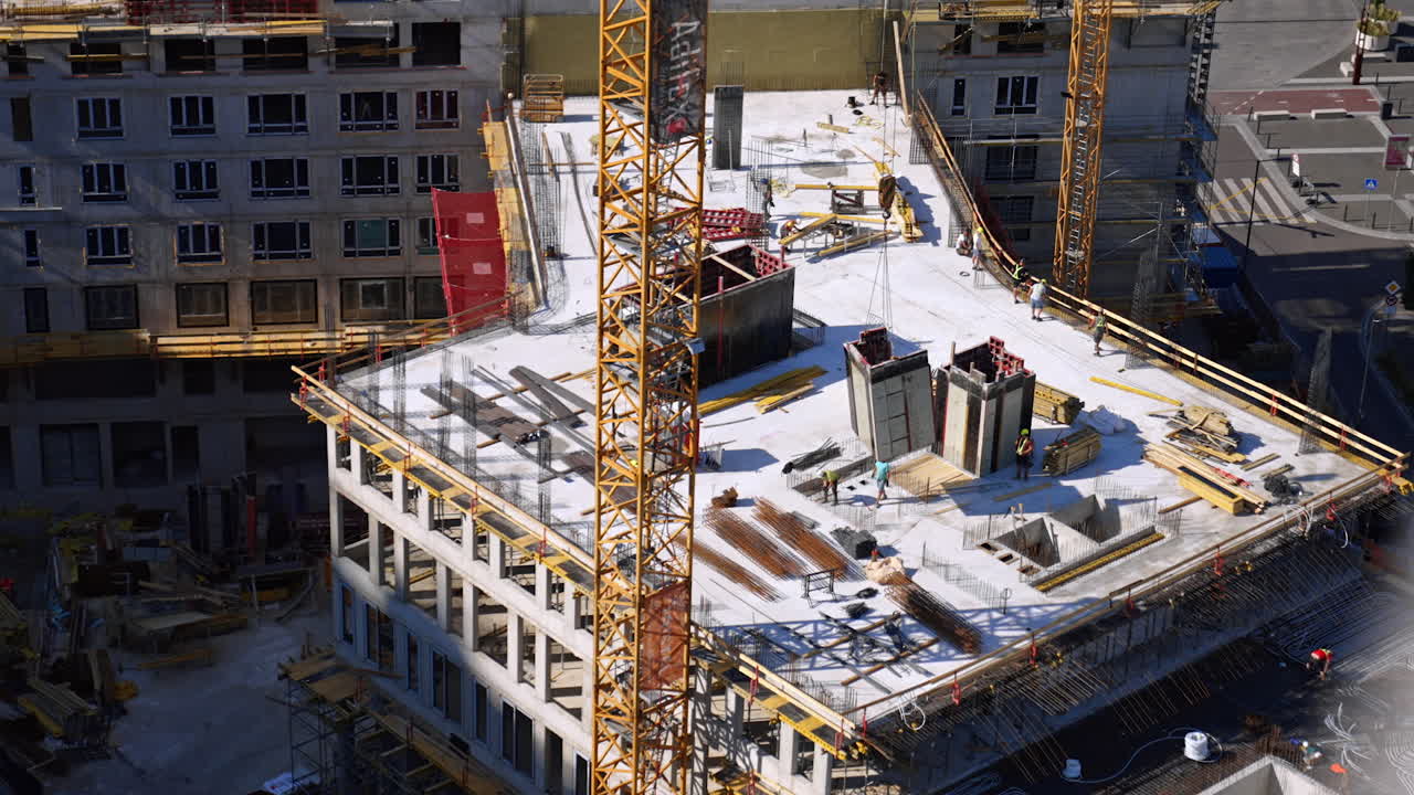 High-rise construction progress. Workers are actively constructing a high-rise building in an urban area during daylight hours, surrounded by cranes