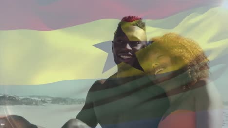 animación de la bandera de ghana sobre una pareja afroamericana en la playa.