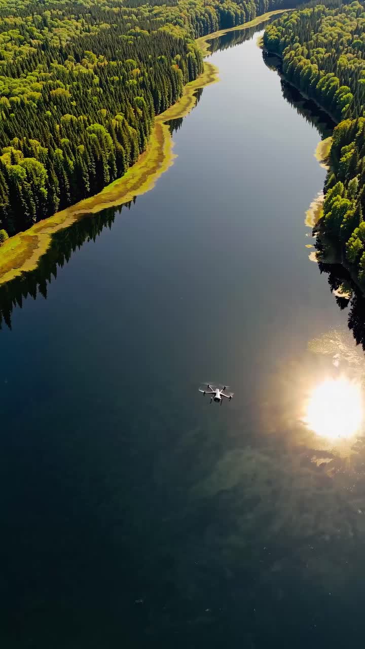 Aerial video captures a serene river winding through lush forests, with a drone flying