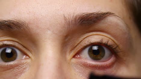 woman uses eye lash curler on her lashes