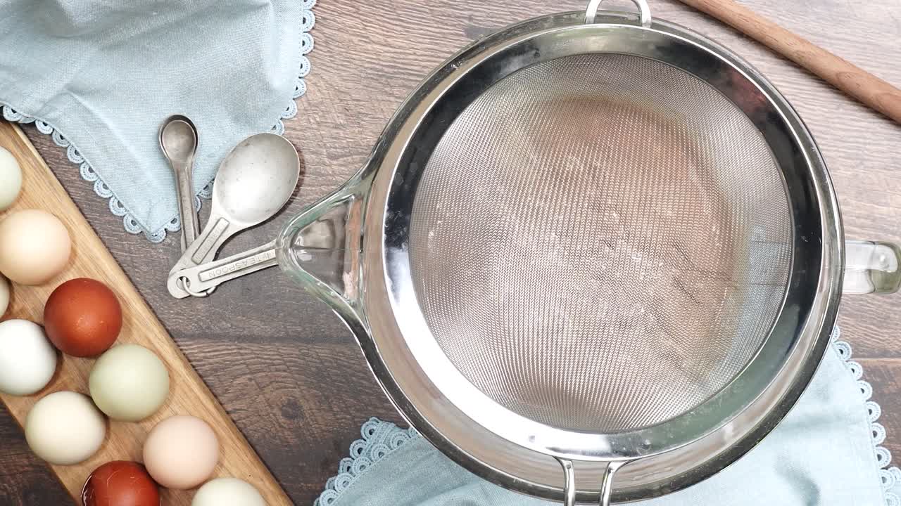 Baking delicious caramel pecan brownies. In a mixing bowl with a flour sifter adding flour and cocoa powder. Freshly baked gooey chocolate brownies with sweet caramel and nutty pecans.