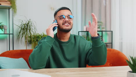 hombre indio feliz involucrado en una conversación agradable llamada telefónica buenas noticias disfrutando de hablar chismes