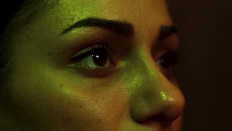 woman watches a screen as colours change close up her eyes