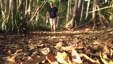 Hombre-Caminando-Por-Un-Sendero-De-Arbustos-Hacia-La-Cámara-En-Cámara-Lenta