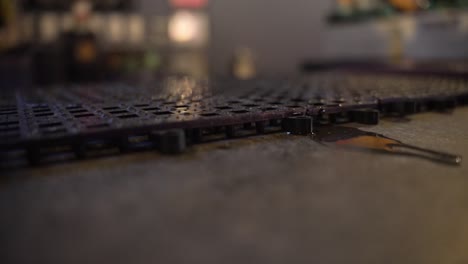 close up of grilled mat on bar counter with liquid in evidence