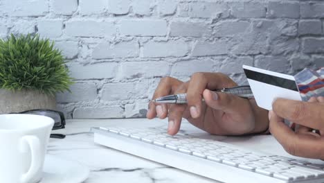 persona que realiza pagos en línea con tarjeta de crédito y teclado