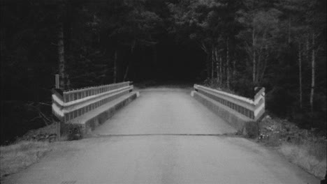 black and white 16mm film of a narrow bridge in the mountains