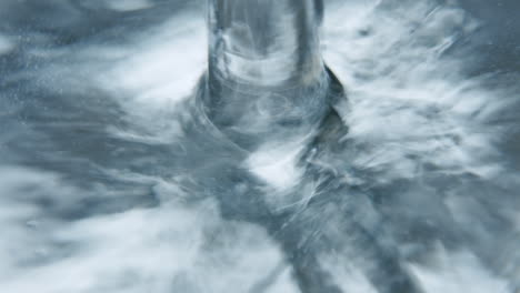 macro shot of water splashing onto a shiny surface water stops at the end of the shot