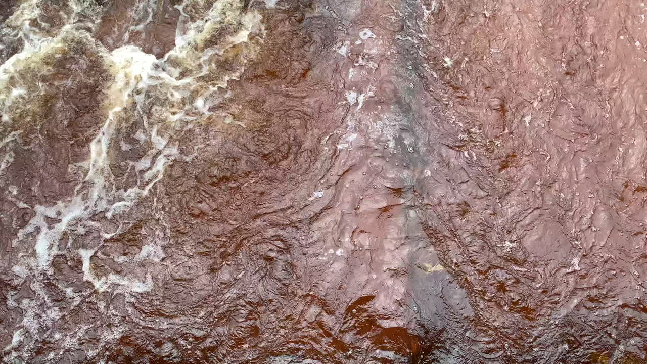 río que fluye a través de la hierba bajo la lluvia, toma panorámica lenta de abajo hacia arriba