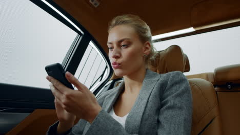 una mujer de negocios seria leyendo malas noticias en su teléfono inteligente.