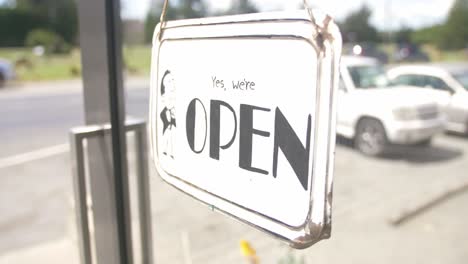 yes we're open signage hanging on the glass door of a store in new zealand - closeup shot