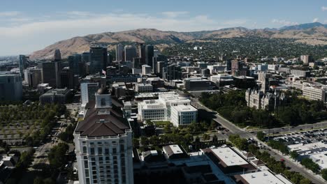 Drone-shot-of-The-Grand-American-Hotel-sitting-amidst-Salt-Lake-City's-downtown-streets