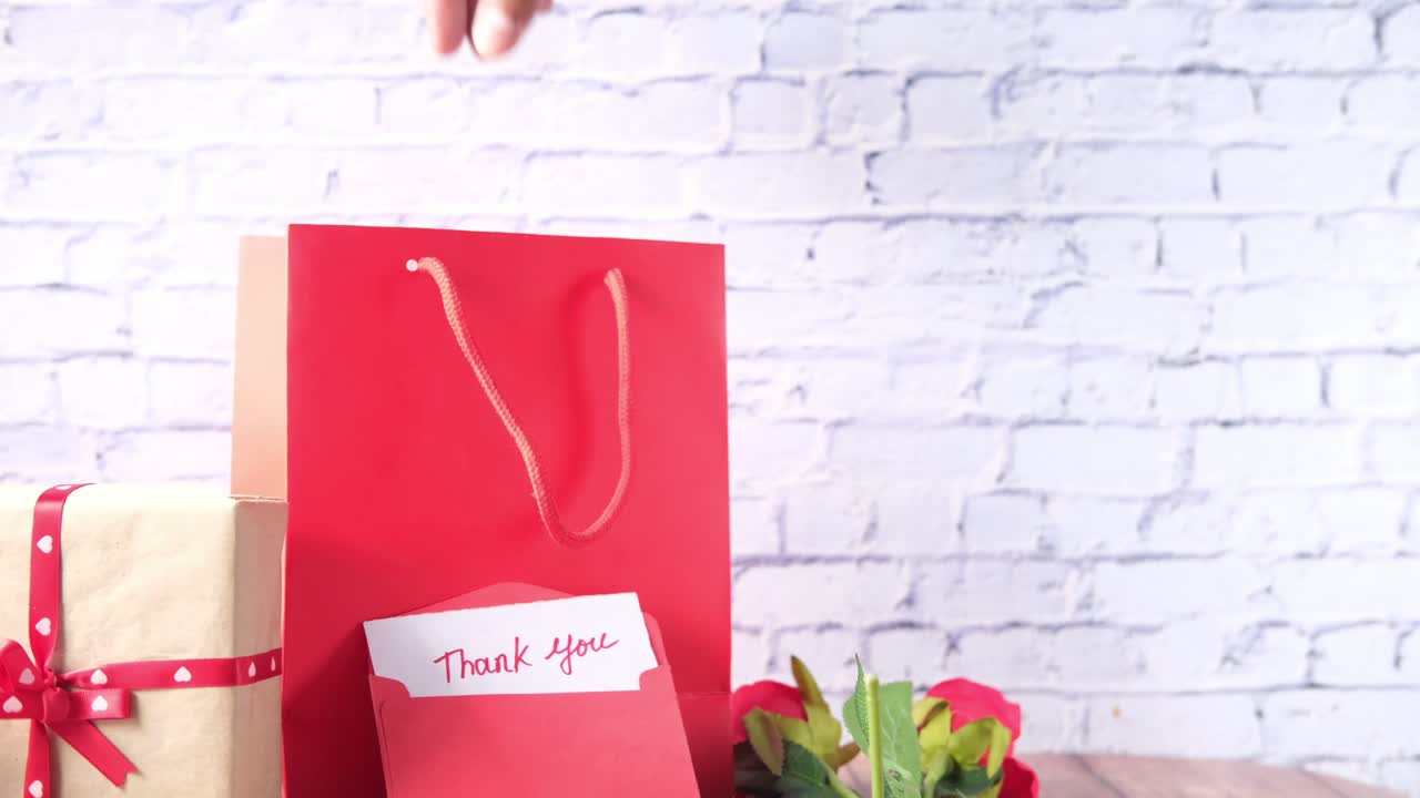 bolsa de regalos roja, regalos y una tarjeta de agradecimiento