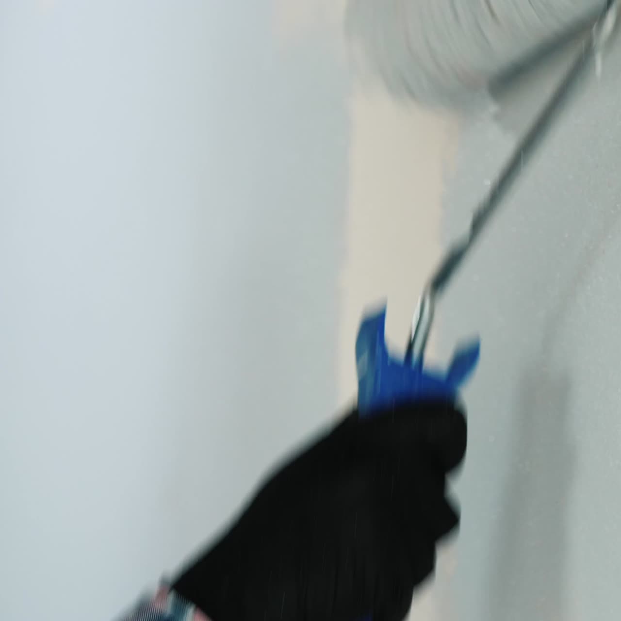 dos constructores pintan la pared con rodillos de pintura