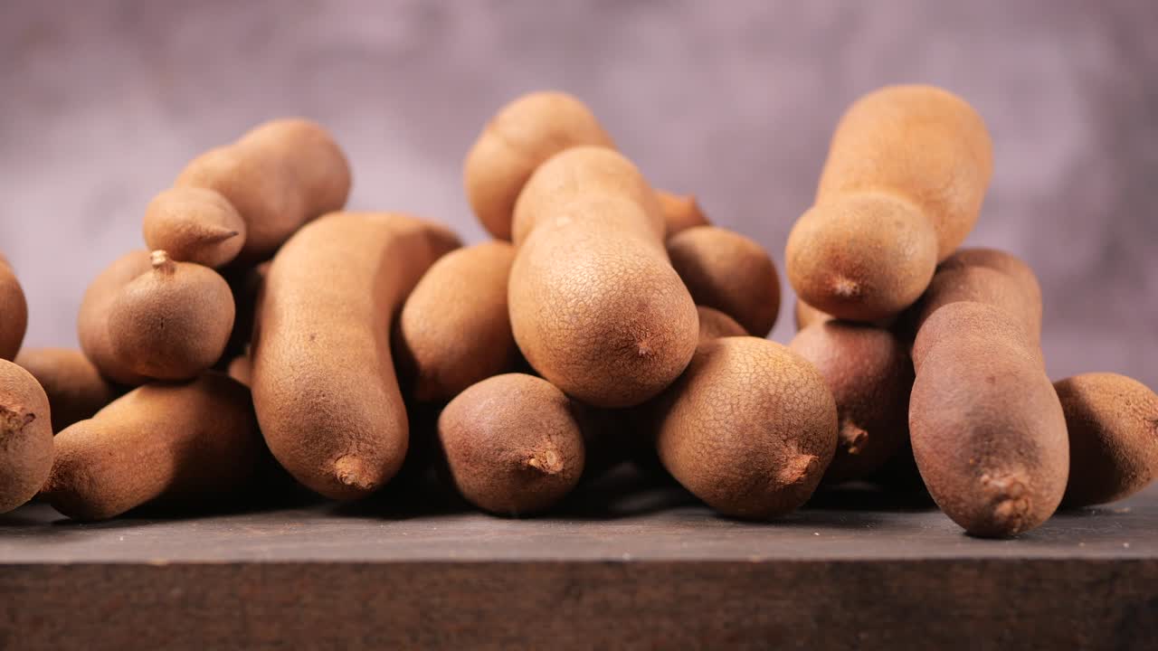 Close-up de vagens de tamarindo frescas empilhadas em uma superfície de madeira