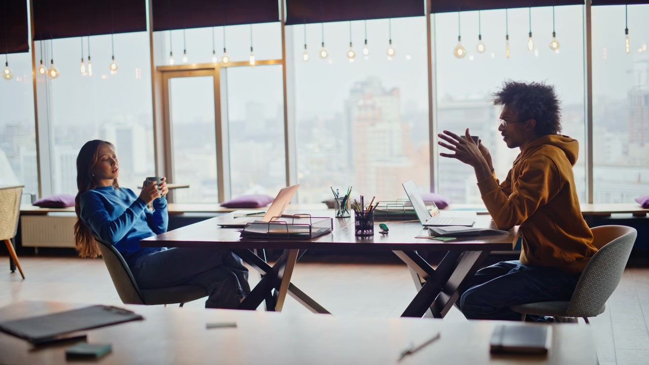 Multiracial coworkers coffee break office. Woman stretching arms relaxed calm.