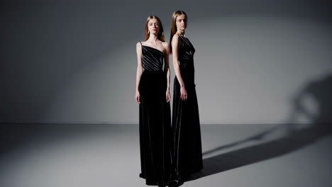 two women in black velvet dresses