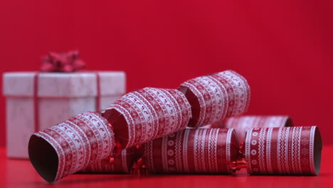 Christmas-Cracker-Fallen-Und-Hüpfen-Neben-Geschenk-Auf-Rotem-Hintergrund