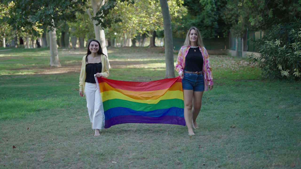 Two Women Holding a Pride Flag in a Park
