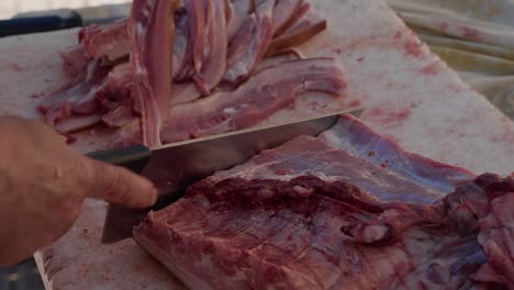 slow motion cut of pork slab by hand during north portugal butchering ritual