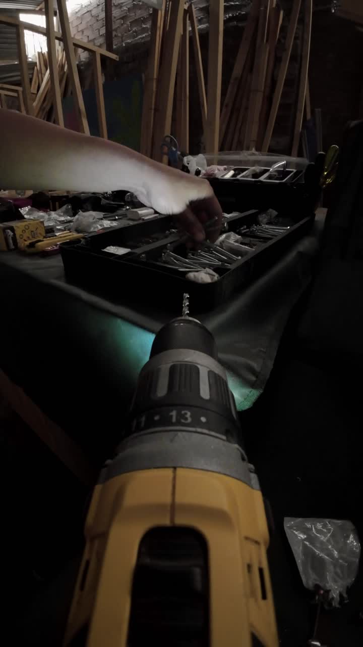 POV Shot of Hand Holding a Drill in a Workshop