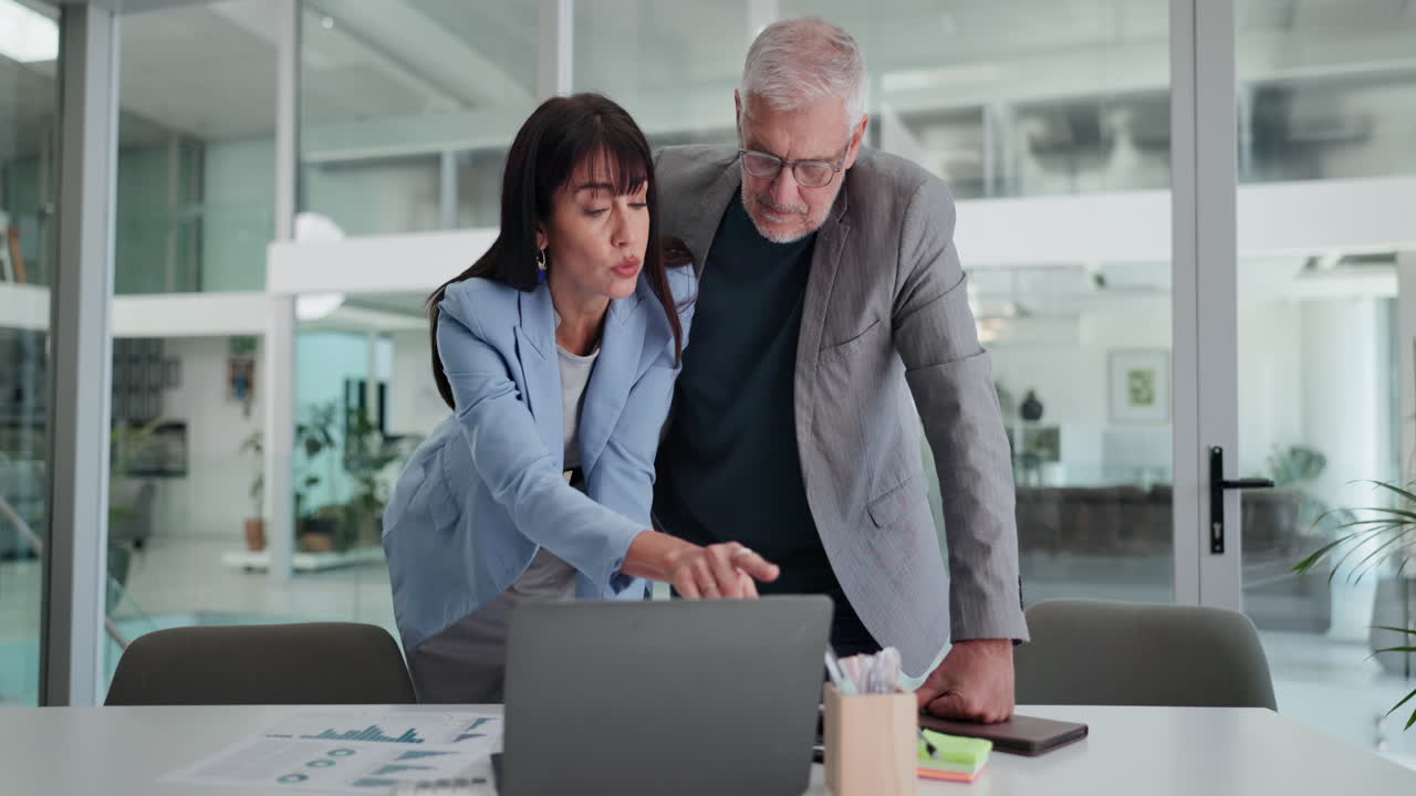 Colleghi di lavoro che discutono di dati su un laptop in un ufficio moderno