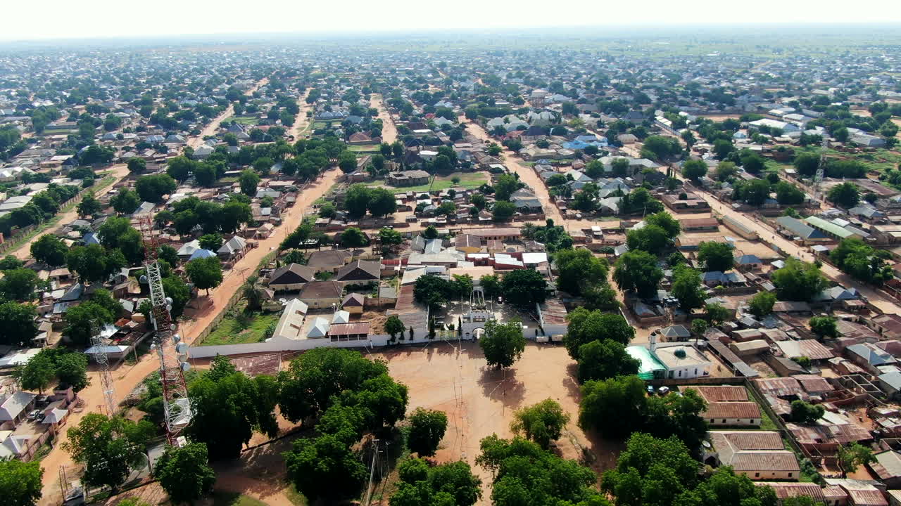 The red dirt streets of Argungu Town in the Kebbi State of Nigeria - pull back aerial flyover