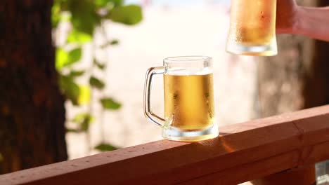 two beer mugs clinking on a sunny day