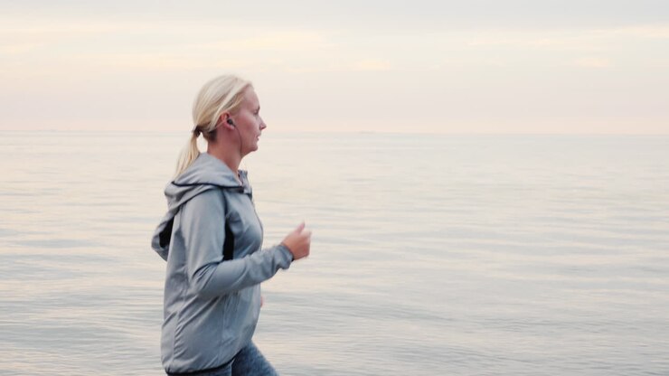 женщина бежит трусцой вдоль берега