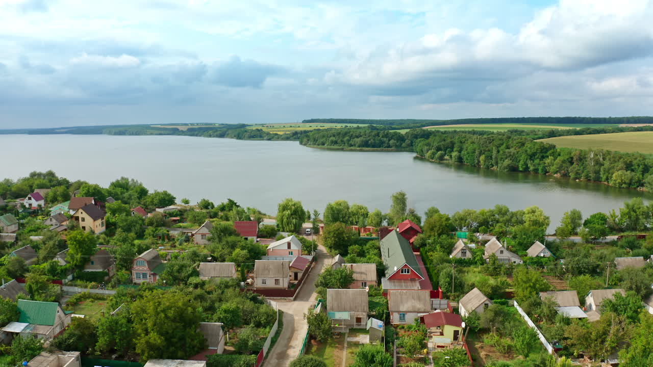 Beautiful view of a village near the river. Lovely houses with a clean river in the foreground. Countryside on nature background. Aerial view.