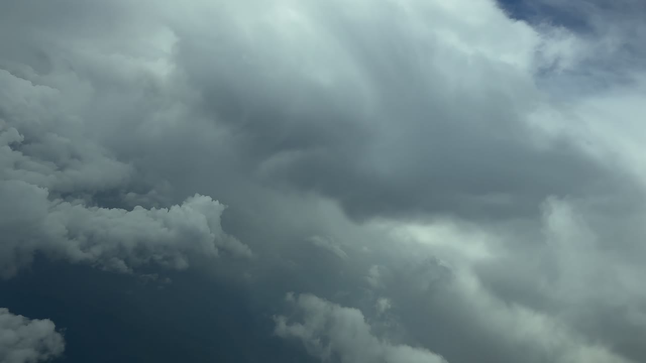 An iimersive pilot’s view from inside an airplane cockpit while flying through threatening storm clouds, doing a left turn to avoid turbulence. 4K