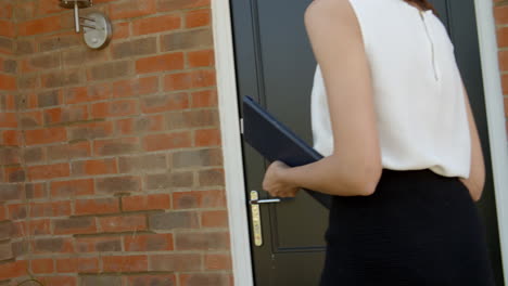 agente de bienes raíces mujer abriendo la puerta principal de la casa para la venta