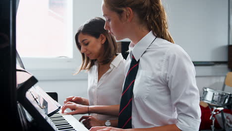 Schülerin-Mit-Lehrer,-Der-Im-Musikunterricht-Klavier-Spielt