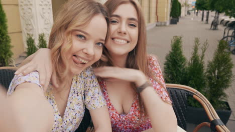 two young women taking a selfie at a cafe