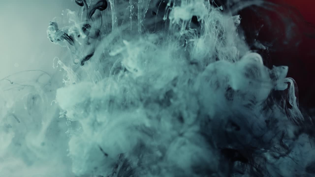 주입된 잉크 색상은 추상적 배경을 가진 액체에 천천히 떨어집니다.