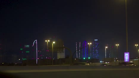 paisaje urbano nocturno con edificios iluminados y tráfico