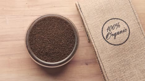 organic ground coffee in glass bowl and burlap bag