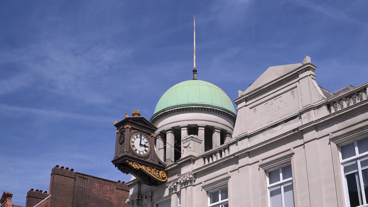La torre del reloj y la cúpula de la Biblioteca Streatham, catalogada como Grado II, se alzan prominentemente contra un cielo azul claro. Adecuado para reportajes históricos o arquitectónicos.