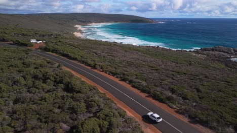 car driving in scenic location with surfing waves in the background